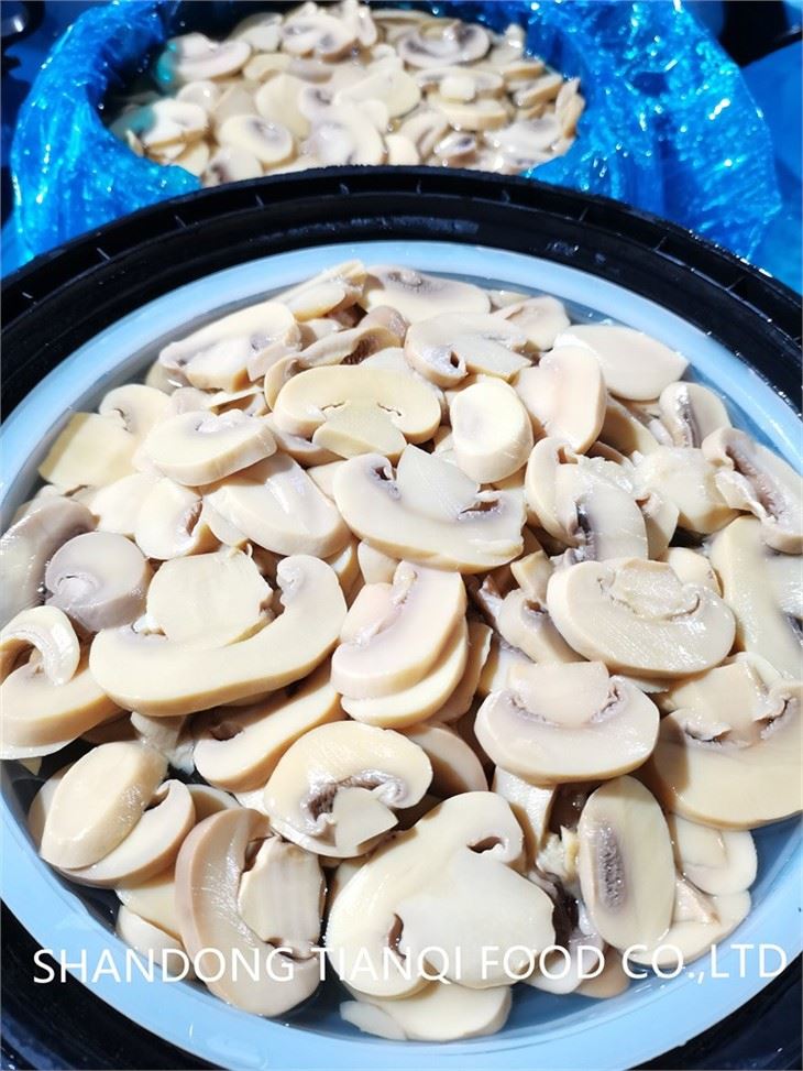Sliced white button mushroom in brine in drums